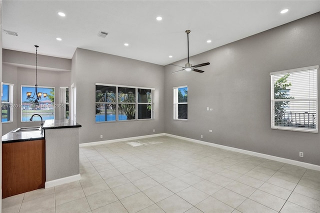 interior space featuring hanging light fixtures, light tile patterned floors, sink, and ceiling fan with notable chandelier