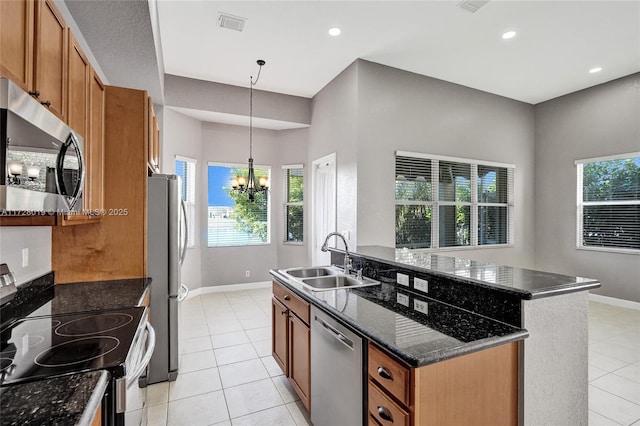 kitchen featuring an inviting chandelier, an island with sink, stainless steel appliances, hanging light fixtures, and sink