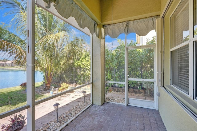 unfurnished sunroom with a water view