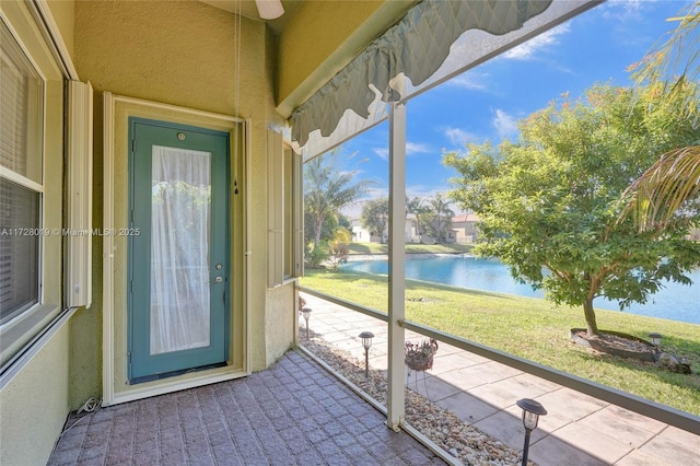 unfurnished sunroom featuring a water view