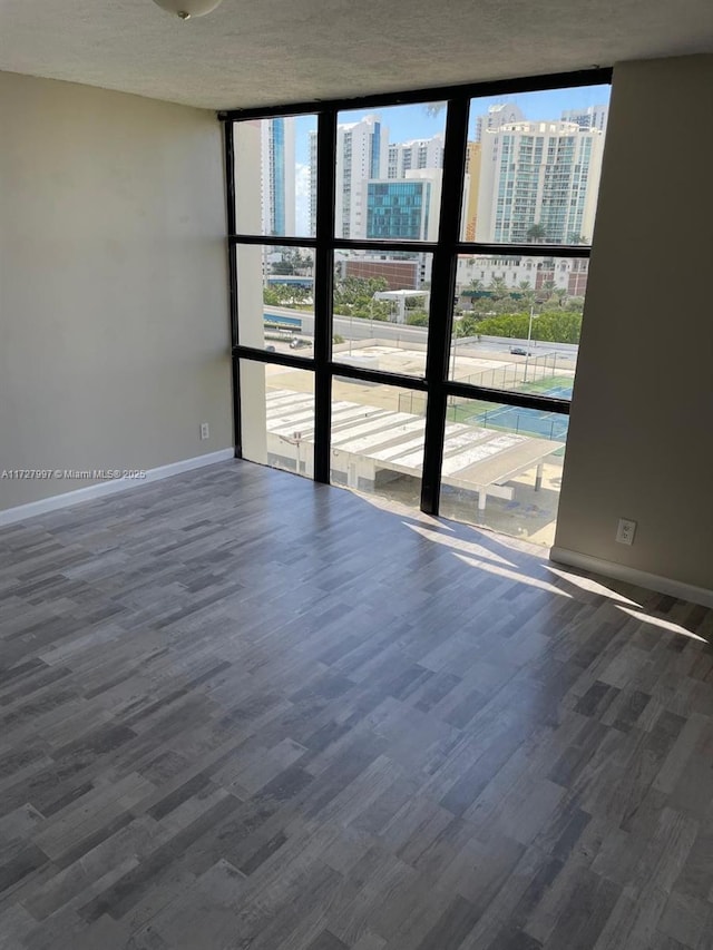 spare room with hardwood / wood-style flooring and floor to ceiling windows