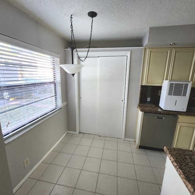 kitchen with hanging light fixtures, a textured ceiling, cream cabinets, and tasteful backsplash