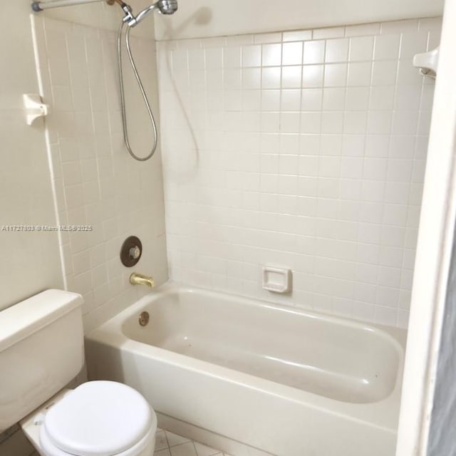 bathroom with toilet, tiled shower / bath combo, and tile patterned flooring