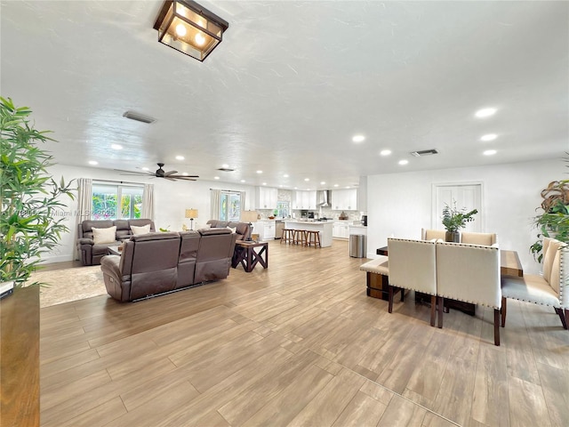 living room with ceiling fan and light hardwood / wood-style floors