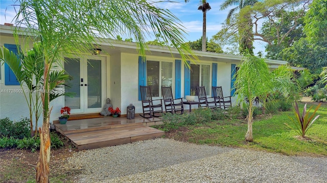 doorway to property featuring a porch and french doors