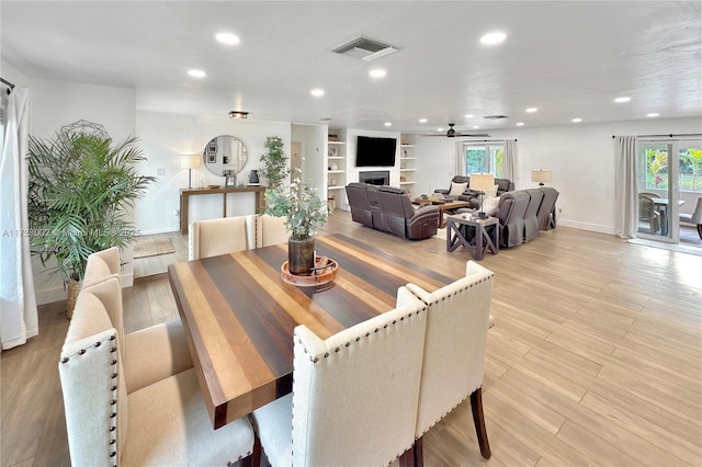 dining area featuring ceiling fan, built in features, and light hardwood / wood-style flooring