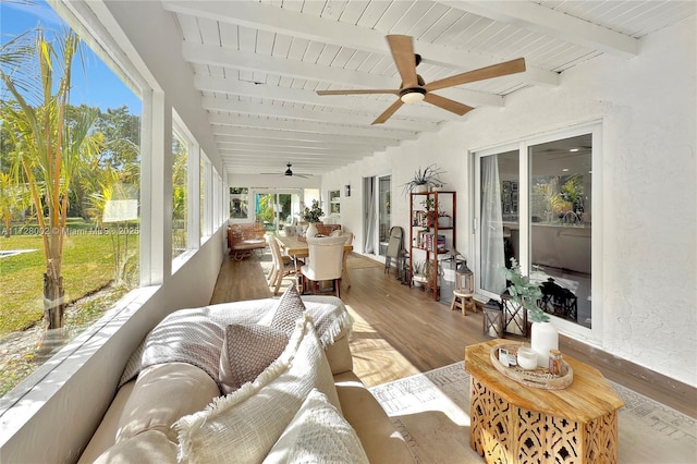 sunroom featuring ceiling fan, wooden ceiling, and beam ceiling