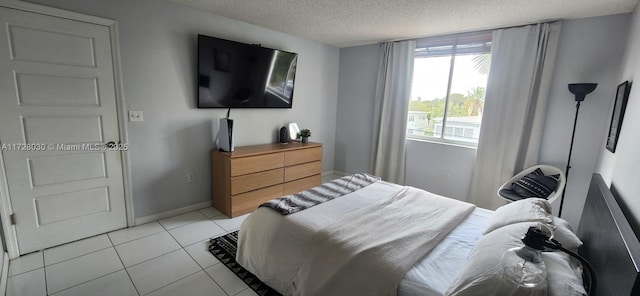 bedroom with a textured ceiling and light tile patterned flooring