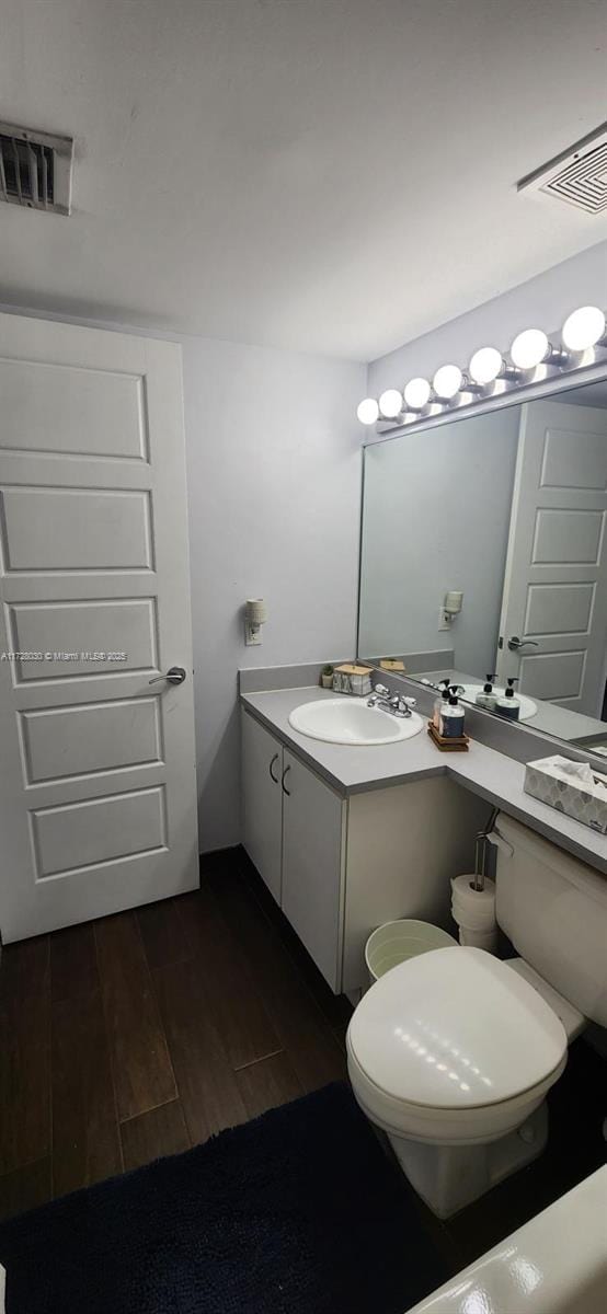 bathroom featuring wood-type flooring, toilet, and vanity