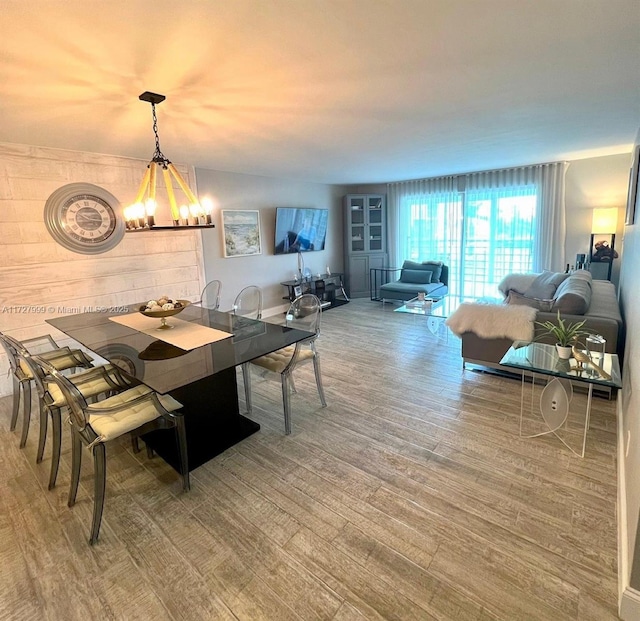 dining space featuring hardwood / wood-style floors and a chandelier