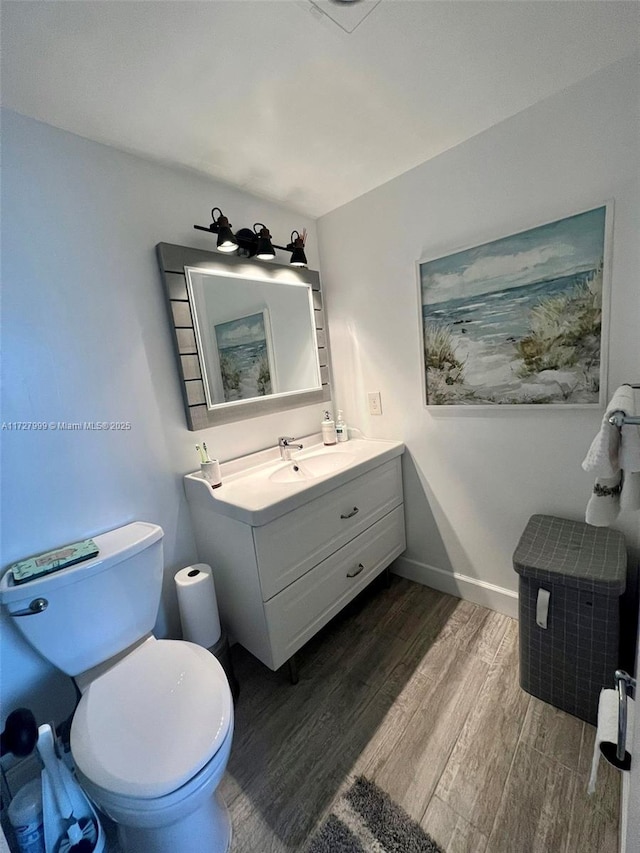 bathroom with wood-type flooring, toilet, and vanity