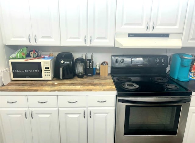 kitchen with butcher block counters, ventilation hood, stainless steel range with electric cooktop, and white cabinets