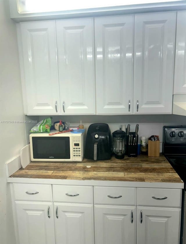 bar with white cabinetry and wooden counters