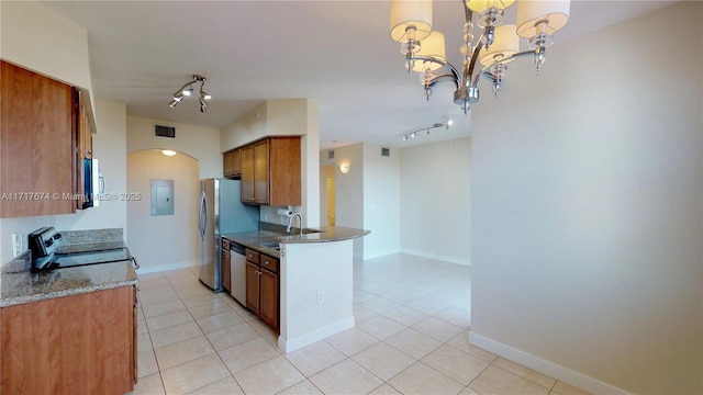 kitchen featuring stone counters, pendant lighting, an inviting chandelier, stainless steel appliances, and light tile patterned floors