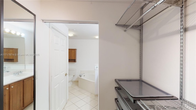 bathroom featuring a bathtub, vanity, toilet, and tile patterned flooring