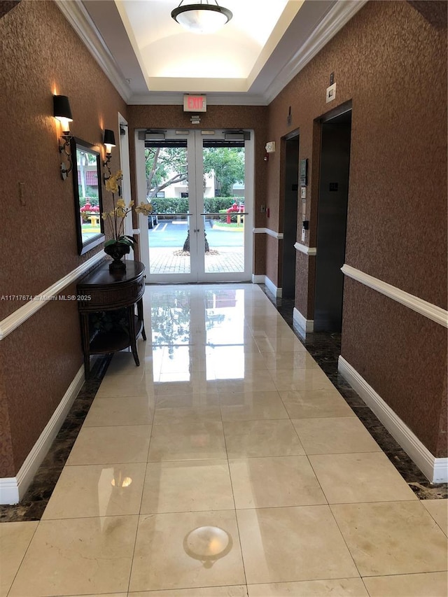 hallway featuring tile patterned flooring, a raised ceiling, crown molding, elevator, and french doors