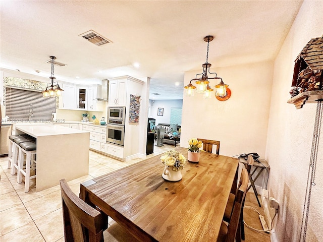 dining space with light tile patterned floors and an inviting chandelier