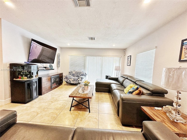 tiled living room featuring a textured ceiling