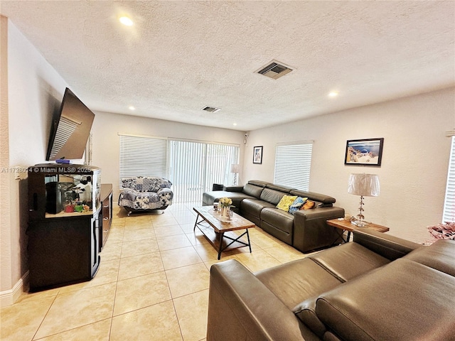 tiled living room featuring a textured ceiling