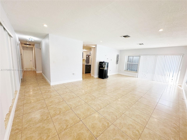 tiled empty room with a textured ceiling