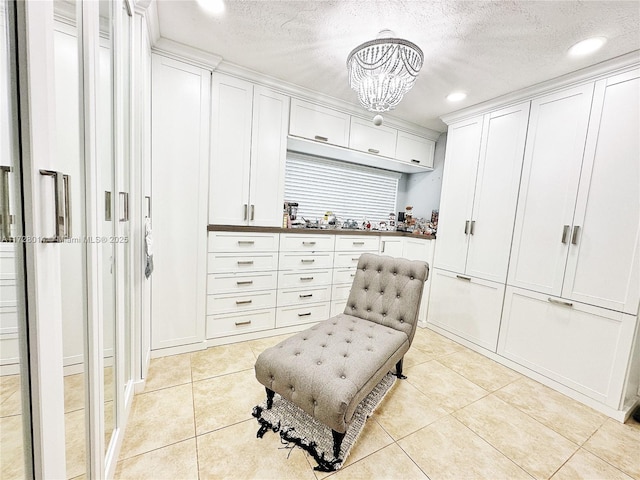 sitting room featuring a textured ceiling, light tile patterned floors, and a chandelier