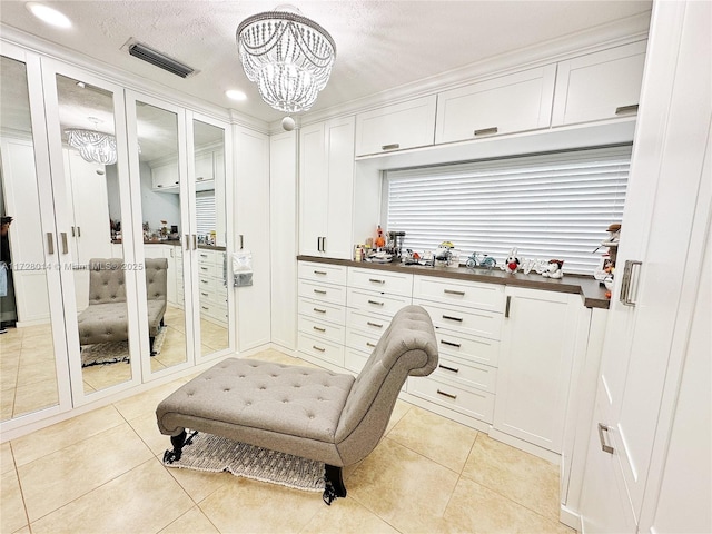 spacious closet featuring a chandelier and light tile patterned flooring