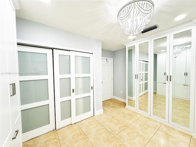 spare room with light tile patterned flooring and a chandelier