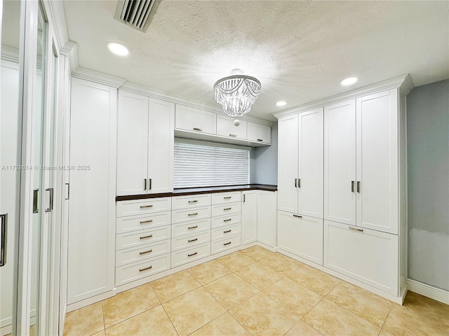 walk in closet with an inviting chandelier