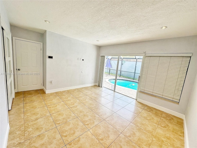 tiled spare room featuring a textured ceiling