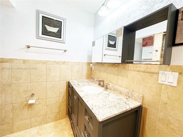 bathroom with tile patterned flooring, tile walls, and vanity