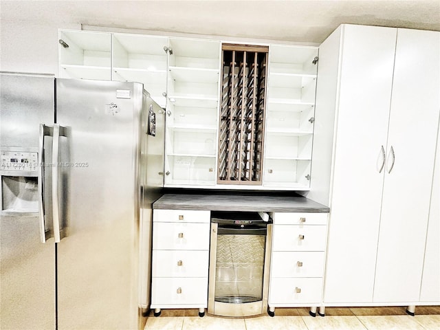 kitchen featuring white cabinetry and stainless steel fridge with ice dispenser