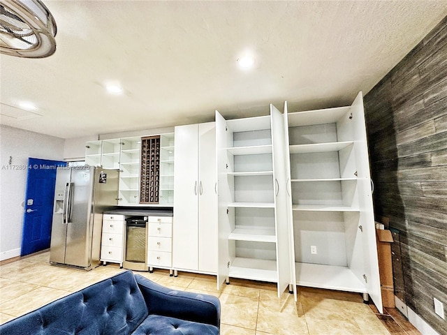 interior space with stainless steel refrigerator with ice dispenser and light tile patterned floors