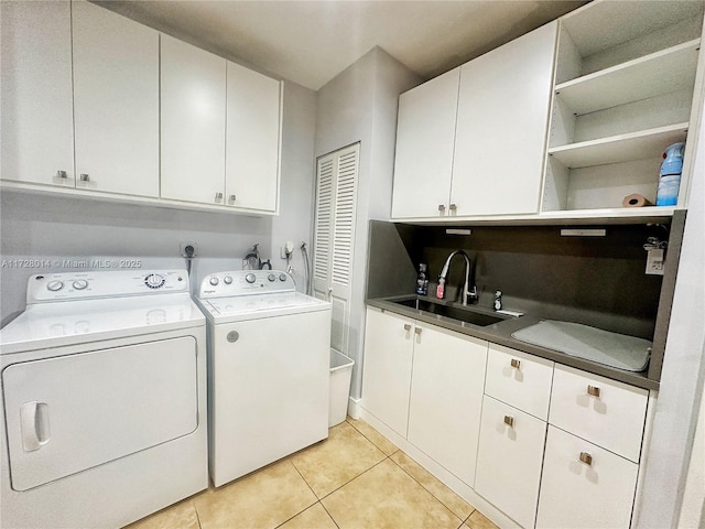 laundry area featuring cabinets, sink, washer and clothes dryer, and light tile patterned flooring