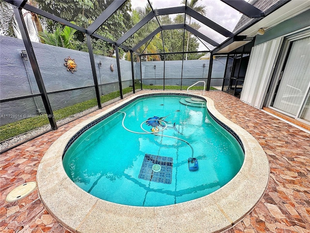 view of swimming pool featuring glass enclosure and a patio