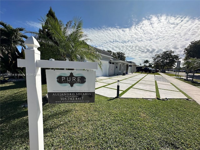 community / neighborhood sign with a yard