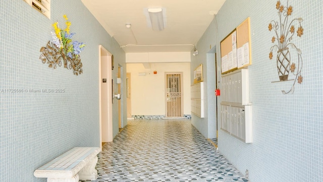 hall featuring tile walls