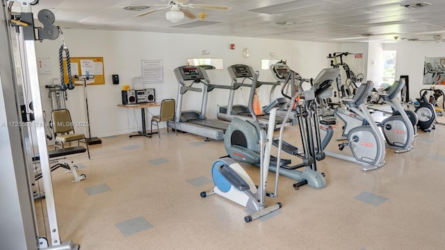 gym with ceiling fan and a paneled ceiling