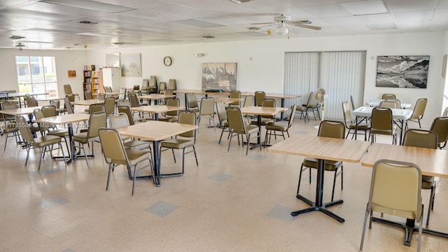 dining area with ceiling fan and a drop ceiling