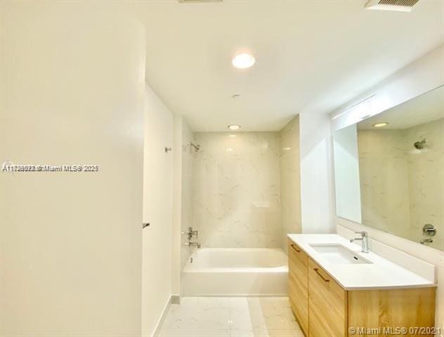 bathroom with vanity and tiled shower / bath