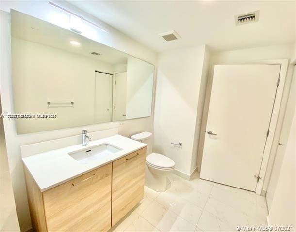 bathroom featuring toilet and vanity