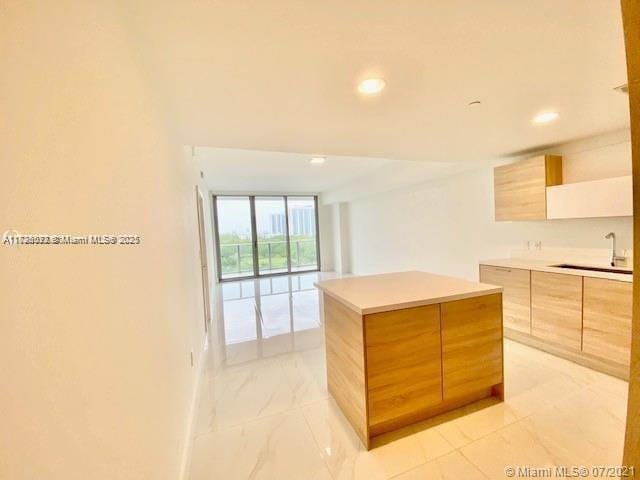 kitchen featuring sink, floor to ceiling windows, and a center island