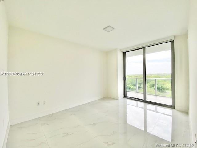 unfurnished room with expansive windows