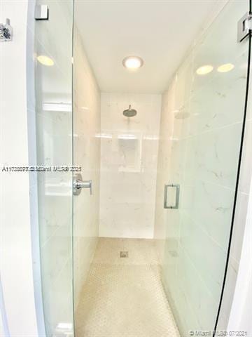 bathroom featuring tile patterned floors and a shower with shower door