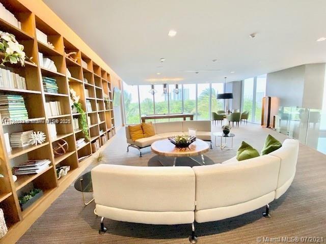 interior space with carpet flooring and a wall of windows