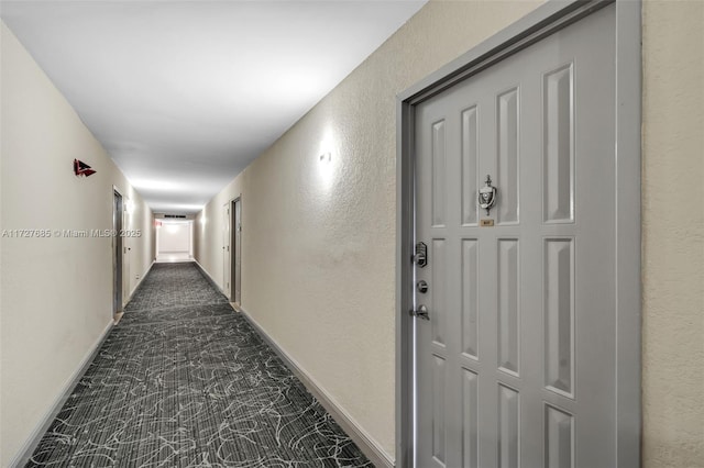 corridor featuring dark colored carpet