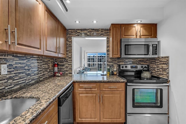 kitchen featuring tasteful backsplash, stainless steel appliances, and dark stone countertops