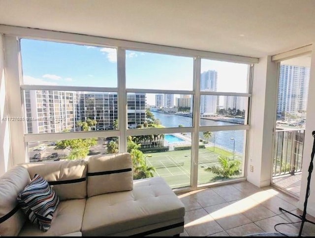 sunroom featuring a water view