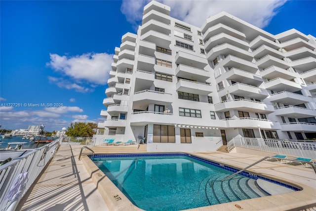 view of swimming pool with a patio area and a water view