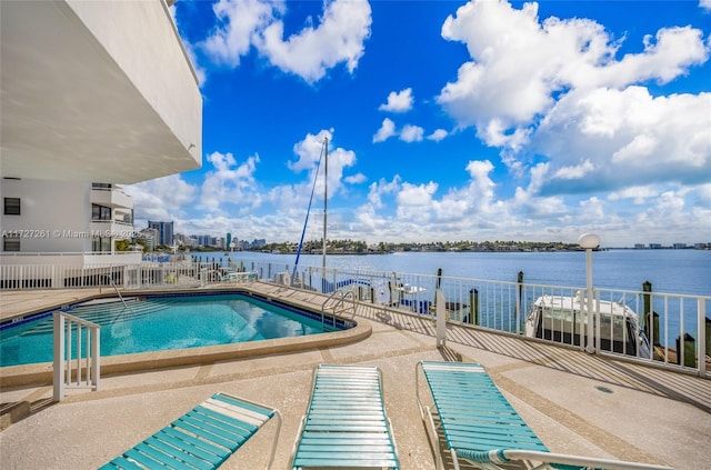 view of pool featuring a patio area and a water view