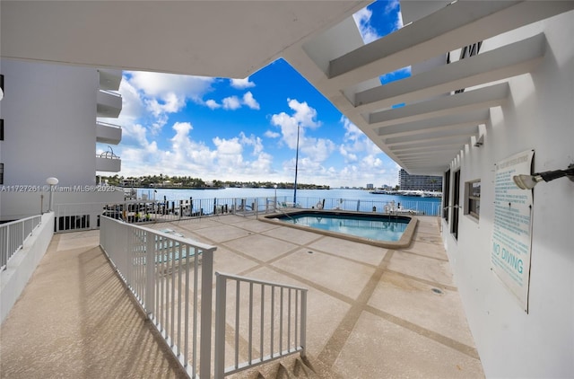 view of pool with a patio area and a water view